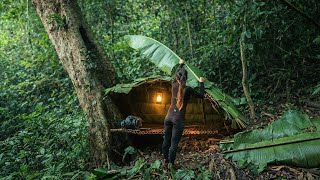 Building a shelter from forest leaves, the girl survives alone in the wilderness.