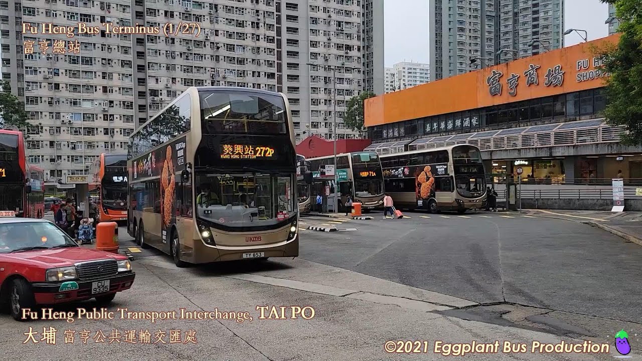 Several double-decker buses are parked at Fu Heng Public Transport Interchange near Tai Po, with high-rise residential buildings in the background and orange and white signage on a nearby shopping mall.