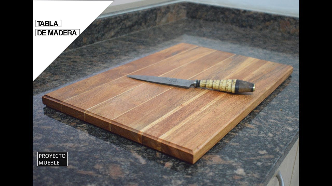 Cortar la tabla de madera en la mesa de la cocina de madera