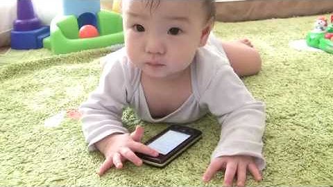 baby playing touch screen cell phone