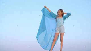 Relaxed Girl In Transparent Blue Tunic On Wind Standing In Desert On Sky Landscape. Beautiful Young