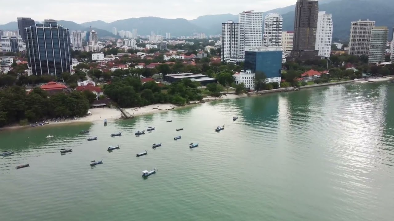 Flying Around Penang: Ocean Green. Bird eyes view of the beach beside Gurney Drive. (4K Video).