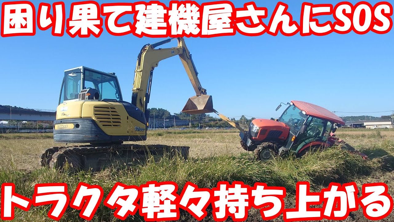 A backhoe is used to rescue a tractor that has slipped off a farm