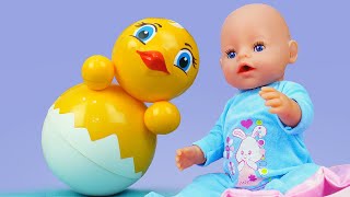 Oyuncak bebek Baby Born hacıyatmaz oyuncak ile oynuyor. Palyaço bebeğe lazımlığı gösteriyor