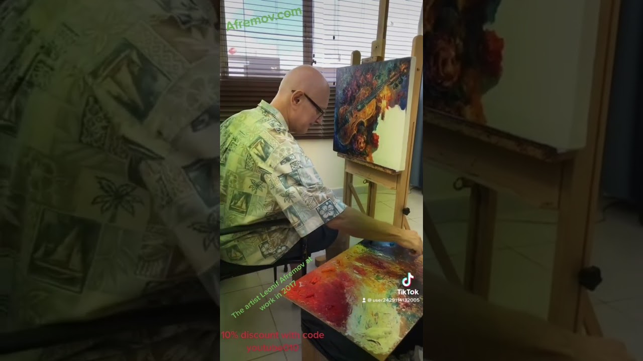 Artist Leonid Afremov during artistic process in 2017 making an original oil painting on canvas