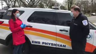 MD1 founder Dr. Mark Merlin shows CBS News reporter Jessica Layton how to wear a surgical mask