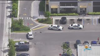 Woman struck after shooting between 2 cars in NW Miami-Dade