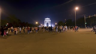 Timelapse of vehicles moving in fast motion and people crossing road at India Gate
