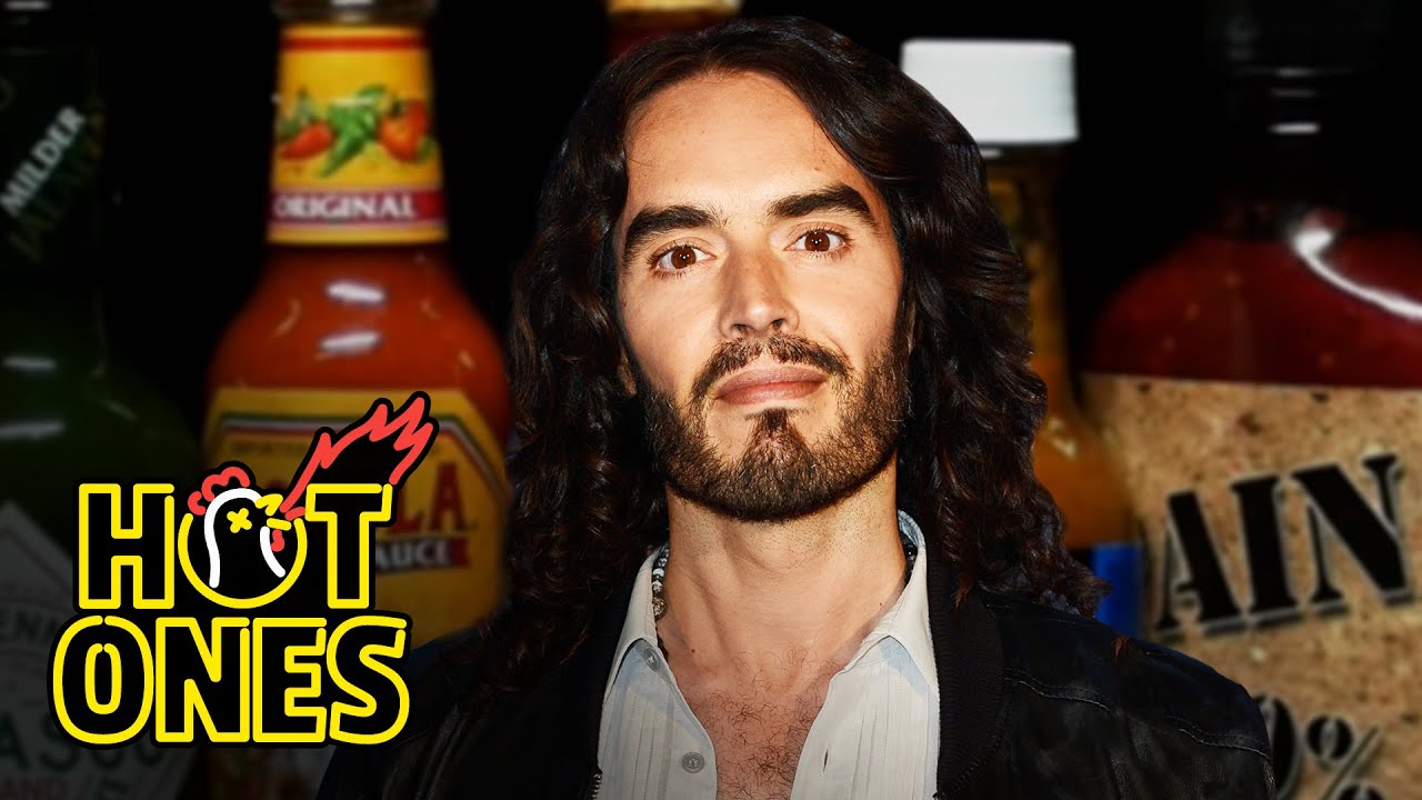Russell Brand Serenades Superfan Brett Baker While Eating Spicy Wings | Hot Ones | First We Feast