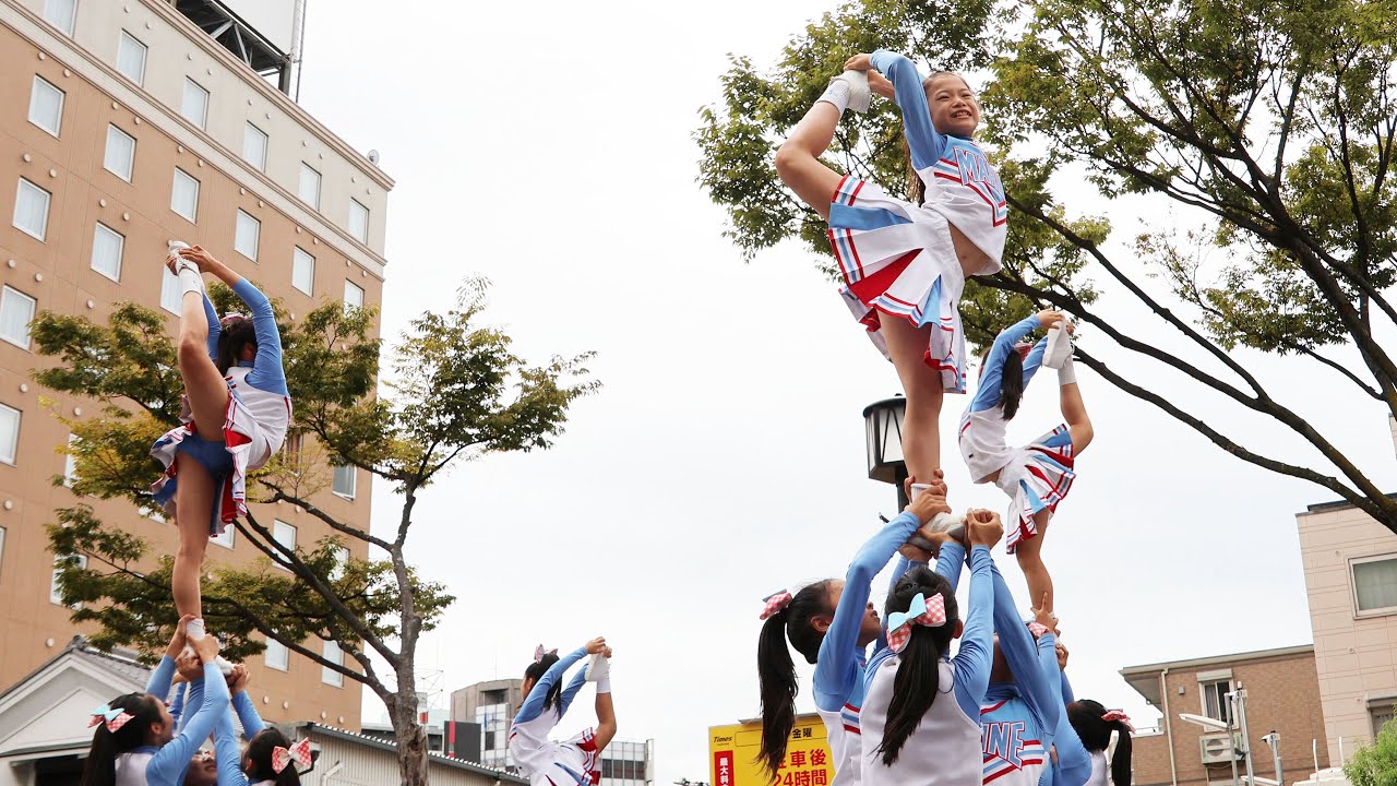 空中開脚で美しいフォームのチアパフォーマンス