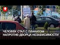 Человек с плакатом «Саша, забери трудовую» напротив Дворца независимости днем 23 сентября