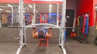 Laying Smith Machine Long Bar Facing Up Two Hand Reverse Push Up Feet On Step Back