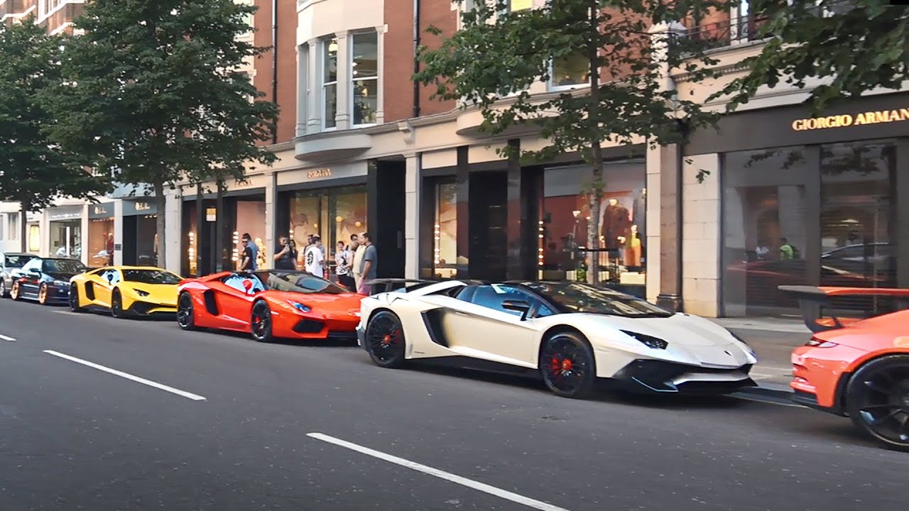 Sloane Street, London, UK, 20th July 2018. The driver of a yellow  Lamborghini gives the event the thumbs up. Supercars, high-performance and  classic cars, as well as some characterful adaptions, line up