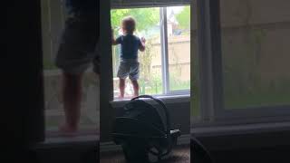Mom calls out boy's name while he is standing near window