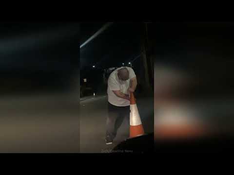 Video shows 'zombie-like' man blocking road and attacking car with a cone