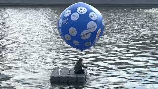 Performance on Moscow rive. Parting with sanctions brands. Text on ballon “Goodbye!”