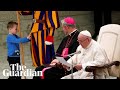 Pope Francis chuckles as boy climbs on stage and interrupts speech