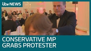 Moment Tory MP forcibly removes protester during speech, prompting calls for him to quit | ITV News