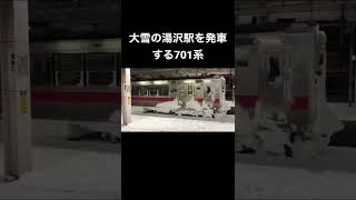 大雪の湯沢駅を発車する701系