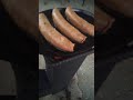 Smoked rabbit sausage on rocket stove