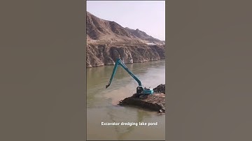 Long reach excavator dredging deep pond