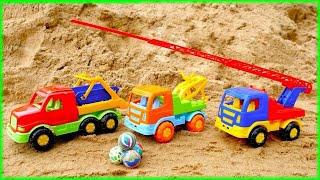 Se divertindo na areia com caminhões. Os carros juntam as bolas.