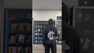 Artist casually goes to vending machine to get a snack. His silver logo sneakily promoting him