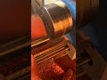 shaping a piece of rotating wood on a lathe machine to create a smooth cylindrical woodwork design