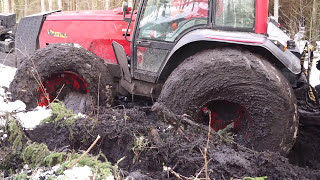 Valtra forestry tractor logging in wet forest, deep mud, difficult conditions