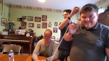 Young people trying to use a rotary phone.