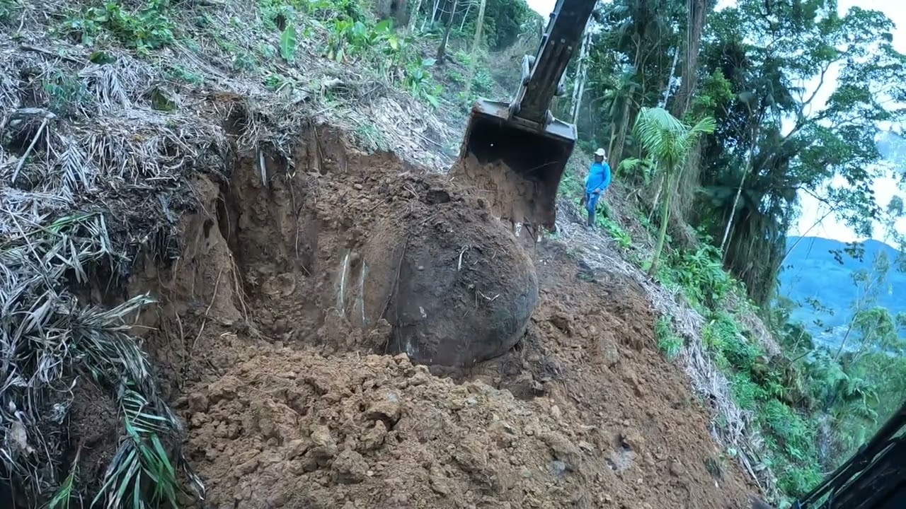 escavadeira abrindo estrada com muita pedra