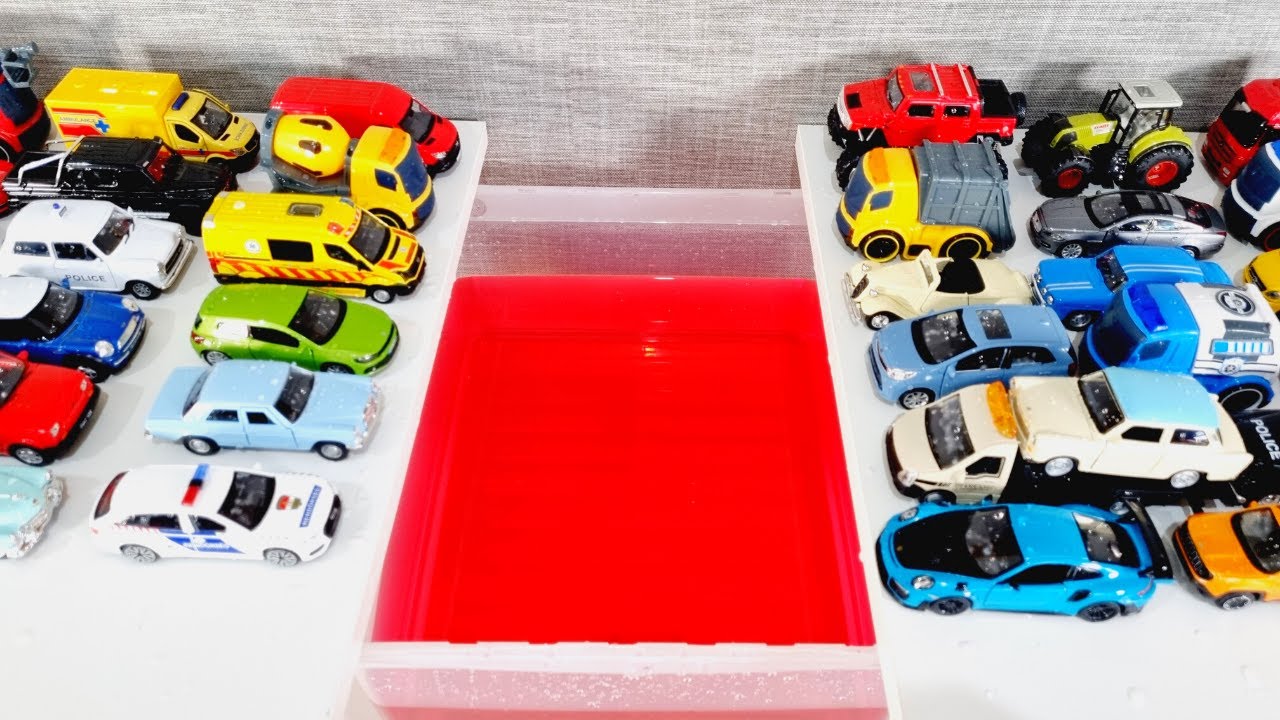 Lot of diecast cars and truck falling into red water
