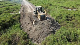 Awesome Mighty bulldozer and truck building new road across forestry swamp