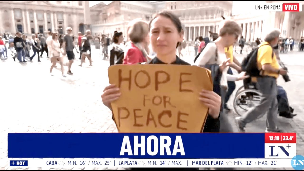 Yona Tukuser holds a "HOPE FOR PEACE" sign in St. Peter's Square at the Vatican during the Conclave