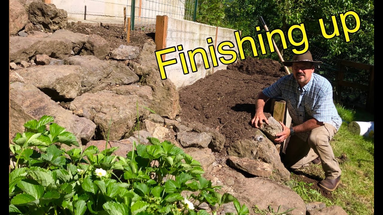 Finishing the terraced retaining wall and raised bed garden.  Rock steps up to house.
