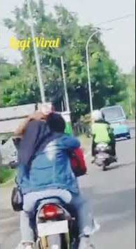 Sejoli Ciuman di Atas Sepeda Motor yang Tengah Melaju