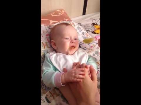 дочка пробует пюре со вкусом брокколи)