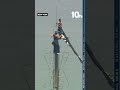 Two people unfurl banner at tippy top of Empire State Building
