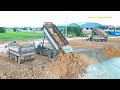 Scania dump truck unloading dirt and Shantui bulldozer pushing dirt