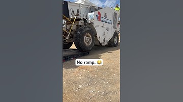 Shuttle buggy coming off lowboy with no ramp.