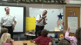 Firefighters teach students about smoke detectors and other fire safety measures.