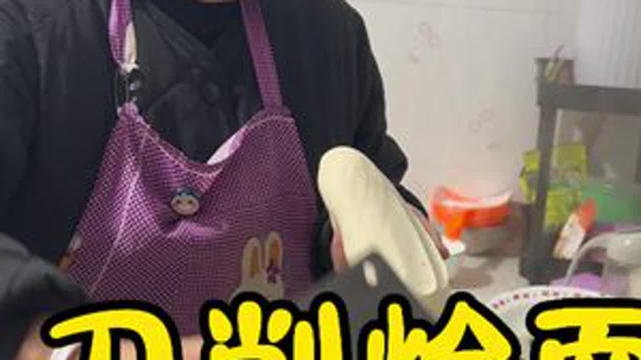 寒冬，厨房。妈妈系着旧围裙，在冷灶前忙碌起来。她有力的手揉着面团，再抄起削刀，面片如雪纷纷落入滚水。灶火映红她的脸，锅里汤底咕噜翻滚，热气腾腾弥漫。配菜一放，调料一撒，一碗碗刀削面端上桌，满室生...