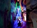 Glowing Gemstone Pool Beneath a Majestic Rocky Waterfall