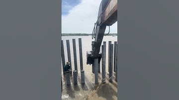 cận cảnh máy xúc đóng cọc bê tông giữa sông