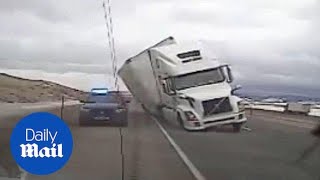 Terrifying moment strong wind blows truck onto police car - Daily Mail