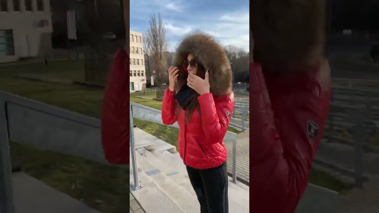 Red shiny short jacket with a large hood and lush fur trim on the hood. Красная блестящая куртка.