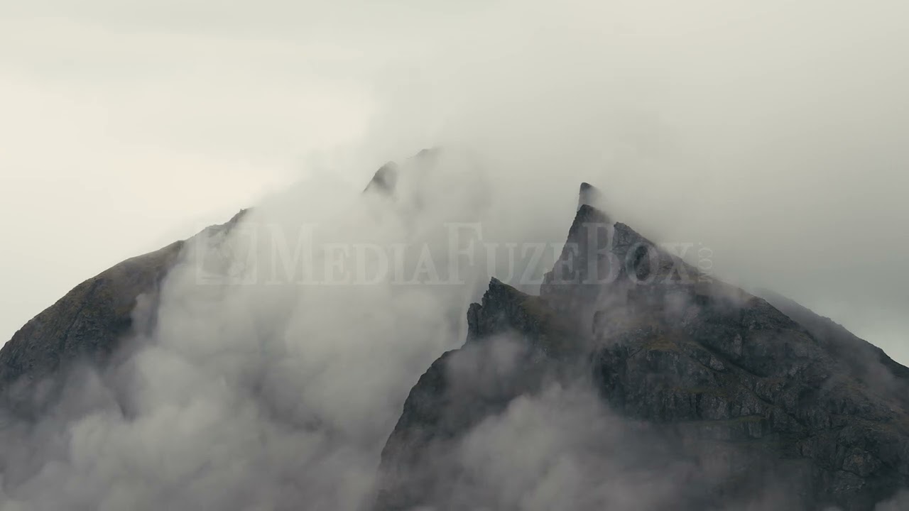 Stock Video - Foggy clouds blowing over jagged mountain top in Iceland