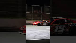 car race featuring high-speed action on a lit track.