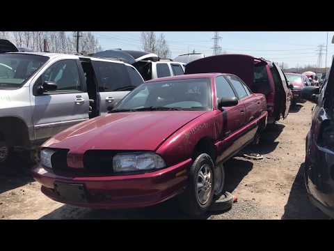 90s Oldsmobile Achieva at the junk yard