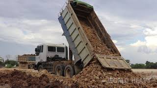 Bulldozer Pushing Dirt And Dump Truck At Work